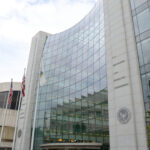 "Washington, DC, USA - October 4, 2012: The United States Securities and Exchange headquarters building located on F Street in Washington, DC. A security guard and other people are present in this photo. The U.S. Securities and Exchange Commission hold primary responsibility for enforcing federal securities laws."