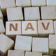 Net asset value (NAV) value of an entity's assets minus the value of its liabilities concept, cube wooden block with alphabet combine the word NAV on black chalkboard background