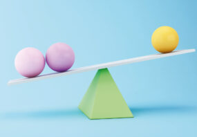 Graphic of two purple spheres and one yellow sphere balancing on top of a green triangle