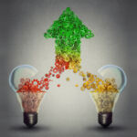 Churchill partners with Seviora on fund ABS Teaming up concept: two open glass light bulbs releasing gears cogs coming together in the shape of upward arrow symbol
