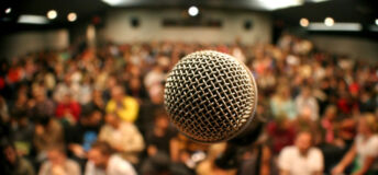 A mic in front of a packed theater.