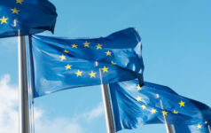 EU insurer regs unlikely to prompt boom in fund ABS Row of blue EU flags in Brussels. The blue flags have twelve yellow stars depicting the original number of member states.