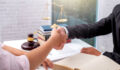 Businessman shaking hands to seal a deal with his partner lawyers or attorneys discussing a contract agreement.