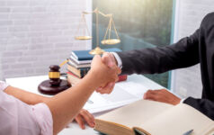 Businessman shaking hands to seal a deal with his partner lawyers or attorneys discussing a contract agreement.