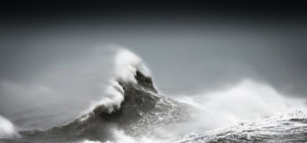 Photograph of a big wave in black and white.