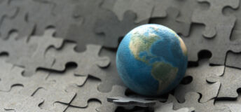 Graphic of a globe on a puzzle that is breaking.