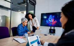 Coworkers collaborating on AI project during business meeting in office