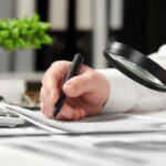 Businessman working in office and calculating finance. Using magnifying glass. Business financial accounting concept.
