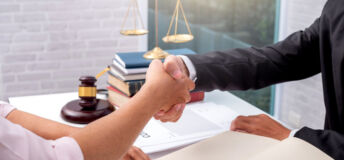 Businessman shaking hands to seal a deal with his partner lawyers or attorneys discussing a contract agreement.