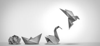 Image of a crumpled up piece of paper next to a paper boat that is next to an origami crane that is next to an origami bird, symbolizing the process of changing for success.