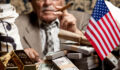 Image of a senior man behind stacks of dollar bills and constitution document.